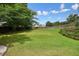 Spacious backyard with a well-manicured lawn, mature trees, and a wooden fence at 3635 Bardfield Ct, Cumming, GA 30041