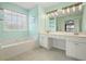 Spacious bathroom featuring a double vanity, large tub, and neutral tile flooring at 3635 Bardfield Ct, Cumming, GA 30041