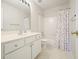 Bathroom with vanity, sink, toilet, shower and tub with colorful polka dot curtain at 3635 Bardfield Ct, Cumming, GA 30041
