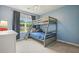 bedroom showcasing a bunk bed, window with backyard view, and blue wall color at 3635 Bardfield Ct, Cumming, GA 30041