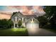Charming two-story home with a well-manicured lawn and a two-car garage, illuminated by sunset at 3635 Bardfield Ct, Cumming, GA 30041