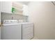 Bright laundry room featuring white washer and dryer, shelving, and neutral wall color at 3635 Bardfield Ct, Cumming, GA 30041