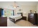 Main bedroom with large window, ceiling fan, wood furnishings and light-colored walls at 3635 Bardfield Ct, Cumming, GA 30041