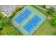 Aerial view of well-maintained tennis courts surrounded by greenery and parking at 3635 Bardfield Ct, Cumming, GA 30041