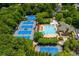 Aerial view showcases tennis courts and a sparkling pool surrounded by lush greenery at 870 Longstone Lndg, Alpharetta, GA 30022