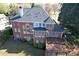 Aerial view of a brick home with a large deck and well-maintained lawn at 870 Longstone Lndg, Alpharetta, GA 30022