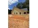 Back view of a single-story yellow home with a gray roof and black framed windows at 103 New Home Rd, Rockmart, GA 30153