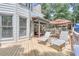 Large wood deck features lounge chairs, dining and seating areas with a partially covered area perfect for relaxation and outdoor entertaining at 1720 Monarch Ct, Cumming, GA 30041