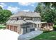 Charming home featuring an attached two-car garage, a spacious deck, and a lush green yard perfect for outdoor enjoyment at 1720 Monarch Ct, Cumming, GA 30041