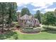 Beautiful brick home with mature trees, lush landscaping, and a spacious lawn at 1720 Monarch Ct, Cumming, GA 30041