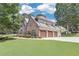 Large two story home showcasing a three-car garage and well-maintained yard in a serene setting at 1720 Monarch Ct, Cumming, GA 30041