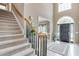 Inviting foyer with a grand staircase, arched doorway and a view into the dining room creates a warm and elegant entry at 1720 Monarch Ct, Cumming, GA 30041