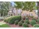 Charming brick home featuring a beautifully landscaped front yard with flowering bushes and mature trees at 1720 Monarch Ct, Cumming, GA 30041