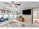 Luxurious main bedroom featuring a tray ceiling, sitting area, TV and detailed wall accents, creating a cozy and elegant retreat at 1720 Monarch Ct, Cumming, GA 30041