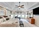 Luxurious main bedroom featuring a tray ceiling, sitting area, TV and detailed wall accents, creating a cozy and elegant retreat at 1720 Monarch Ct, Cumming, GA 30041