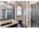Chic powder room featuring dark fixtures, vanity with granite countertops, and bold wallpaper adding a touch of sophistication at 1720 Monarch Ct, Cumming, GA 30041
