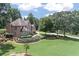 Expansive backyard showcasing lush greenery and mature trees surrounding a brick two-story home at 1720 Monarch Ct, Cumming, GA 30041