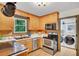 Well-lit kitchen featuring wood cabinets, stainless steel appliances, and a view to the laundry room at 2269 Sparrow Ridge Ne Dr, Marietta, GA 30066