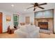 Cozy living room features a stone fireplace, ceiling fan, and picture window views at 2269 Sparrow Ridge Ne Dr, Marietta, GA 30066