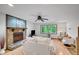 Bright living room with a stone fireplace, ceiling fan, and large windows overlooking trees at 2269 Sparrow Ridge Ne Dr, Marietta, GA 30066