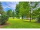 Expansive, lush backyard featuring well-manicured lawn and mature trees and a view of the lake at 2538 Morgan Lake Ne Dr, Marietta, GA 30066