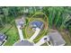 An aerial view showcases this elegant home on a landscaped lot within a cul-de-sac, enveloped by mature trees at 4056 Friendship Creek Dr, Buford, GA 30519