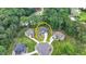 Aerial view of a home nestled in a lush, wooded neighborhood with mature trees and circular driveways at 4056 Friendship Creek Dr, Buford, GA 30519
