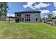 Expansive backyard featuring a covered patio, lush green lawn, and ample space for outdoor activities and entertaining at 4056 Friendship Creek Dr, Buford, GA 30519