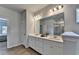 Elegant bathroom featuring double sinks, large mirror, and wood-look flooring at 4056 Friendship Creek Dr, Buford, GA 30519