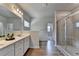 Modern bathroom featuring double sinks, glass shower, and wood-look floors at 4056 Friendship Creek Dr, Buford, GA 30519