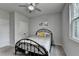 Cozy bedroom features a metal frame bed, neutral carpet, ceiling fan, and a bright window at 4056 Friendship Creek Dr, Buford, GA 30519