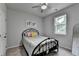 Comfortable bedroom with a metal frame bed, neutral carpet, ceiling fan, and natural light at 4056 Friendship Creek Dr, Buford, GA 30519