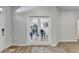 Hallway has wood floors, neutral walls, and french doors leading to the music room at 4056 Friendship Creek Dr, Buford, GA 30519