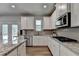 Well-lit kitchen with stainless steel appliances, white cabinets, granite countertops, and access to the outdoors at 4056 Friendship Creek Dr, Buford, GA 30519