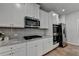 Bright kitchen featuring white cabinets, stainless steel appliances, granite countertops, and wood flooring at 4056 Friendship Creek Dr, Buford, GA 30519