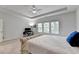Well-lit primary bedroom with a tray ceiling, workstation, and bright windows at 4056 Friendship Creek Dr, Buford, GA 30519