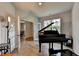Music room features a grand piano, natural light, wood flooring, and open doors at 4056 Friendship Creek Dr, Buford, GA 30519