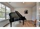 Music room features a grand piano, natural light, and wood flooring at 4056 Friendship Creek Dr, Buford, GA 30519