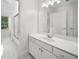Bright white bathroom features a single sink vanity, tiled floors and shower, and bright lights at 745 Glengate Pl, Atlanta, GA 30328