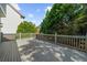 An expansive gray deck with white railings, offering a serene outdoor living space surrounded by green foliage at 745 Glengate Pl, Atlanta, GA 30328