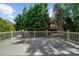 A spacious gray deck surrounded by a white railing and lush trees under a blue sky at 745 Glengate Pl, Atlanta, GA 30328