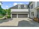 Large two-car garage with dark wooden doors and bright exterior lighting fixtures at 745 Glengate Pl, Atlanta, GA 30328