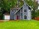 Charming two-story home featuring blue siding, a red front door, and a well-maintained front yard at 1081 Forest Path, Stone Mountain, GA 30088