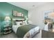 Comfortable bedroom features a queen bed with decorative pillows, a green accent wall, and natural light at 6139 Wayburn St, Tucker, GA 30084