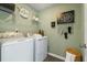 Efficient laundry room with modern washer and dryer, overhead shelving, and stylish decor at 6139 Wayburn St, Tucker, GA 30084