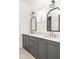 Bathroom features a double sink vanity with marble countertop and vintage-style mirrors and lighting fixtures at 10904 Serenbe Ln, Chattahoochee Hills, GA 30268