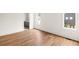 Bright, empty bedroom features hardwood floors, white walls, and natural light from two windows and an ensuite bathroom at 10904 Serenbe Ln, Chattahoochee Hills, GA 30268