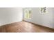 Bright, empty bedroom features hardwood floors, white walls, and natural light from multiple windows at 10904 Serenbe Ln, Chattahoochee Hills, GA 30268