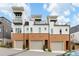 Modern townhome with brick facade, multiple decks, and attached garages at 10904 Serenbe Ln, Chattahoochee Hills, GA 30268