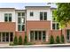 Charming townhome exterior with brick and white siding, featuring a welcoming entryway and well-maintained landscaping at 10904 Serenbe Ln, Chattahoochee Hills, GA 30268